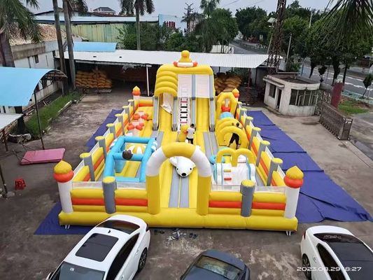 Um pato amarelo com grandes escorregas e um castelo inflável